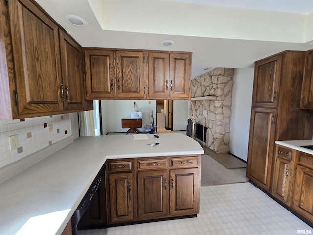 kitchen with tasteful backsplash, a fireplace, and kitchen peninsula