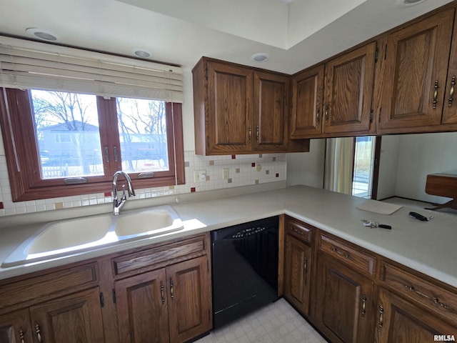 kitchen with tasteful backsplash, black dishwasher, and sink