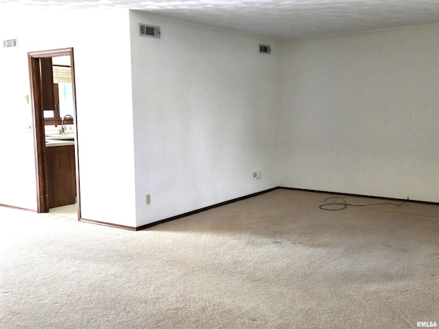 empty room with light carpet and sink