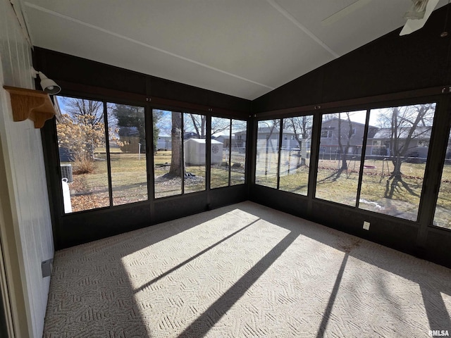 sunroom / solarium with ceiling fan, a healthy amount of sunlight, and vaulted ceiling