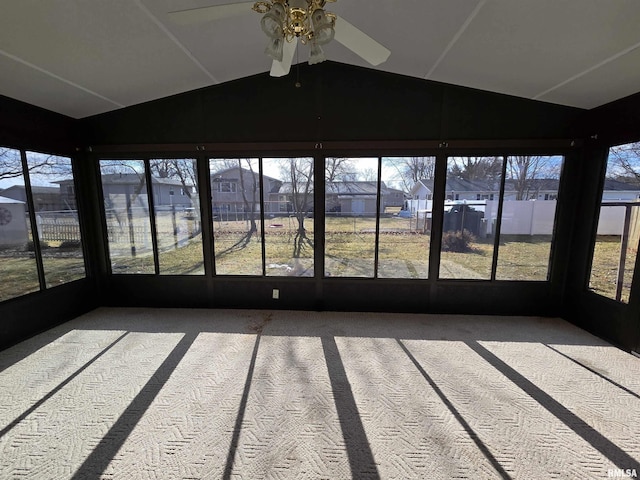 unfurnished sunroom featuring ceiling fan, a healthy amount of sunlight, and vaulted ceiling