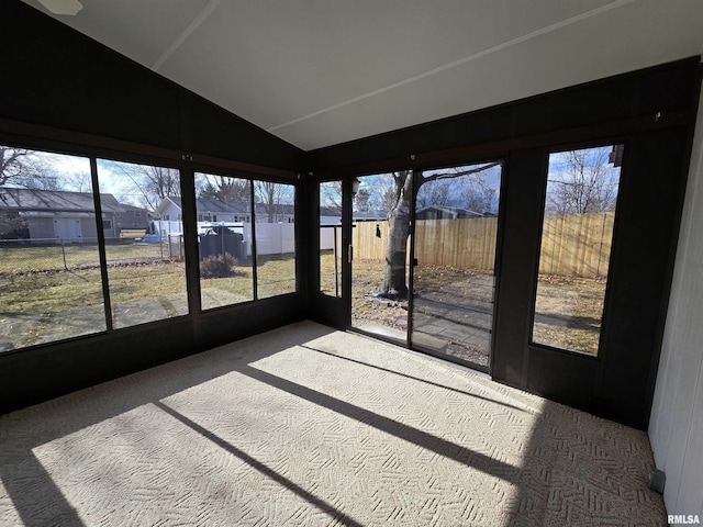 unfurnished sunroom featuring lofted ceiling and plenty of natural light