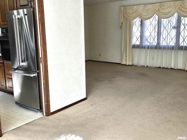 kitchen with high end fridge and light carpet