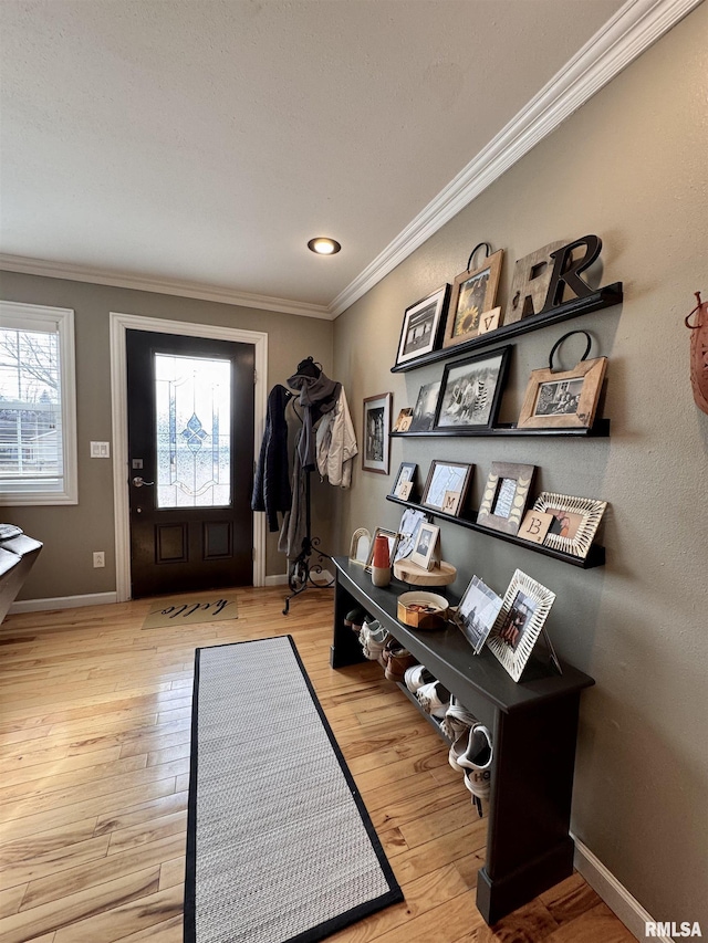 foyer entrance with crown molding and light hardwood / wood-style floors