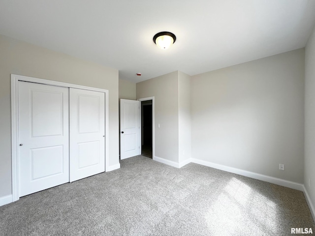 unfurnished bedroom with carpet, baseboards, and a closet