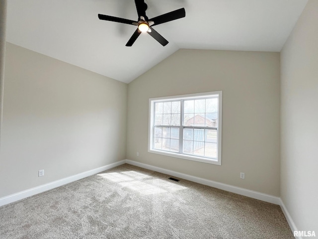 carpeted empty room featuring baseboards, lofted ceiling, ceiling fan, and visible vents