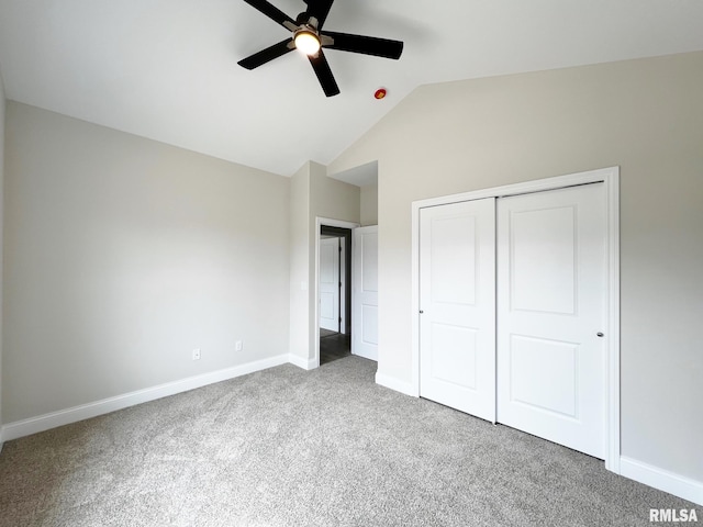 unfurnished bedroom featuring lofted ceiling, carpet, baseboards, a ceiling fan, and a closet