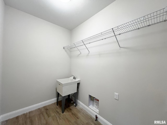 laundry area with wood finished floors, baseboards, laundry area, and washer hookup