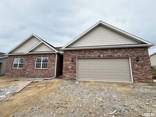 single story home featuring driveway, an attached garage, and brick siding