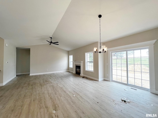 unfurnished living room with vaulted ceiling, wood finished floors, a glass covered fireplace, ceiling fan with notable chandelier, and visible vents