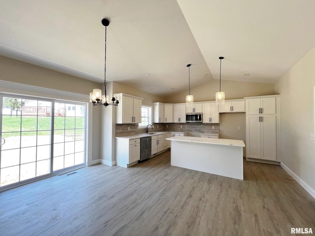 kitchen with decorative backsplash, stainless steel microwave, a kitchen island, a sink, and dishwashing machine