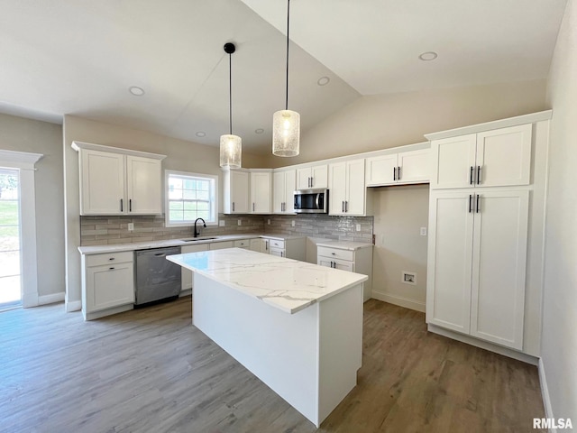 kitchen with a sink, appliances with stainless steel finishes, a center island, light wood-style flooring, and white cabinets