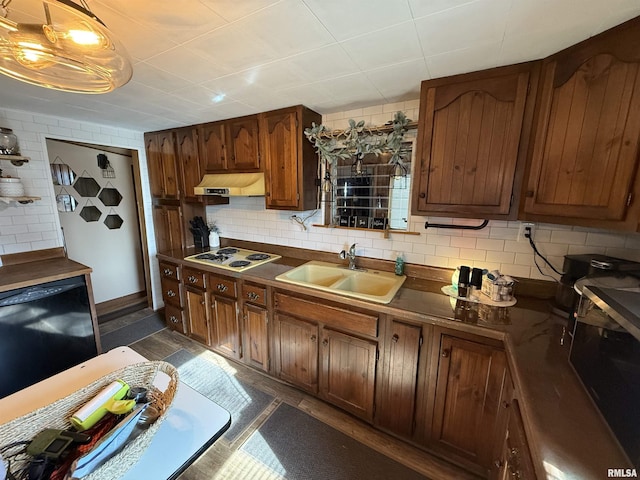 kitchen featuring black dishwasher, sink, white stovetop, and backsplash