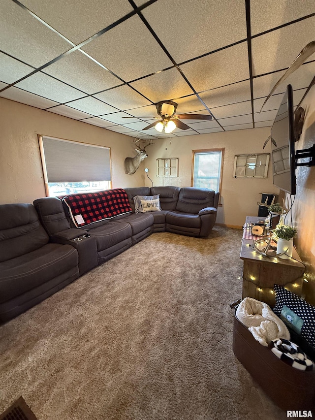 carpeted living room with ceiling fan and a paneled ceiling