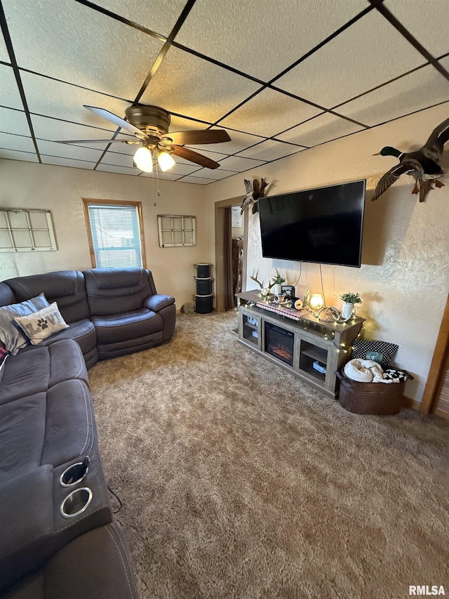 living room with a paneled ceiling, ceiling fan, and carpet flooring