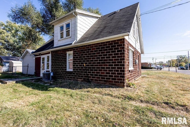 view of side of property featuring central AC unit and a lawn