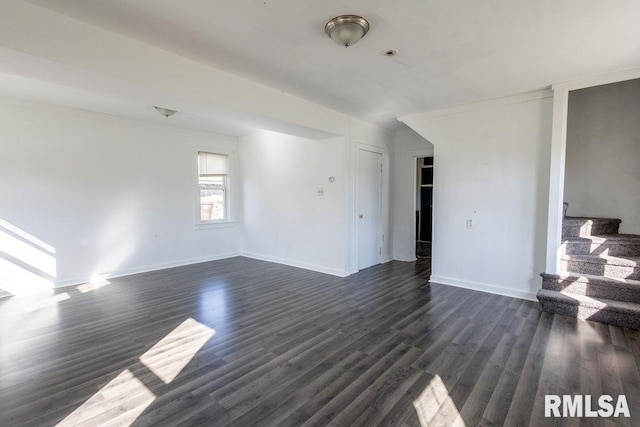 empty room with ornamental molding and dark hardwood / wood-style floors