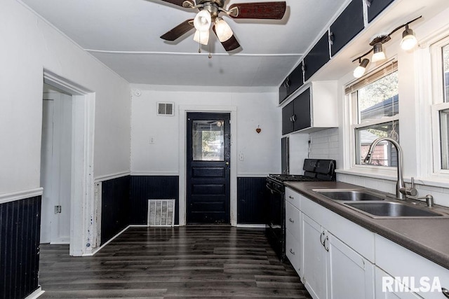 kitchen featuring white cabinetry, sink, black range with gas stovetop, dark hardwood / wood-style flooring, and ceiling fan