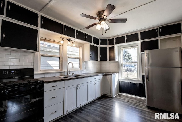 kitchen with sink, stainless steel fridge, a wealth of natural light, black gas range, and white cabinets