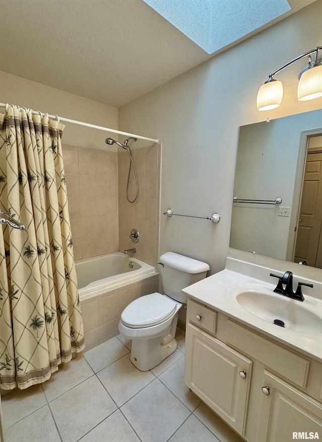 full bathroom featuring tile patterned floors, toilet, a skylight, vanity, and shower / bath combo with shower curtain