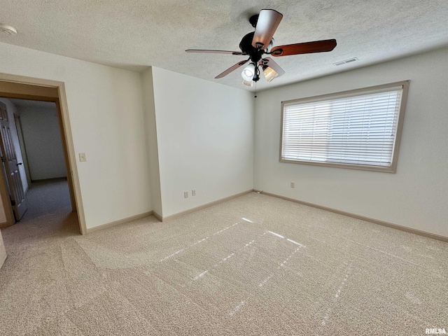 empty room with ceiling fan, a textured ceiling, and carpet flooring