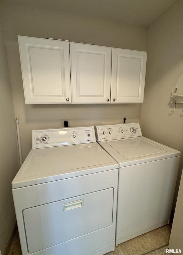 laundry area featuring washer and clothes dryer and cabinets