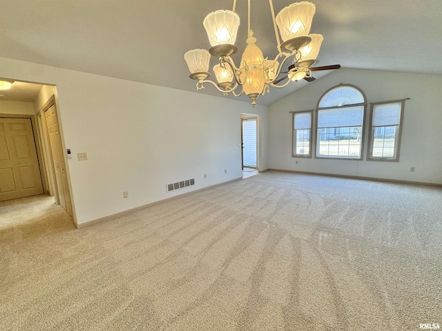 empty room with lofted ceiling, light colored carpet, and a chandelier