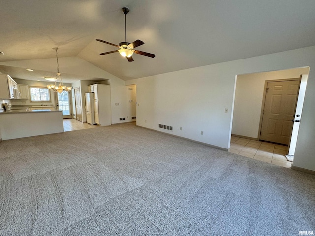 unfurnished living room with light carpet, ceiling fan with notable chandelier, and lofted ceiling