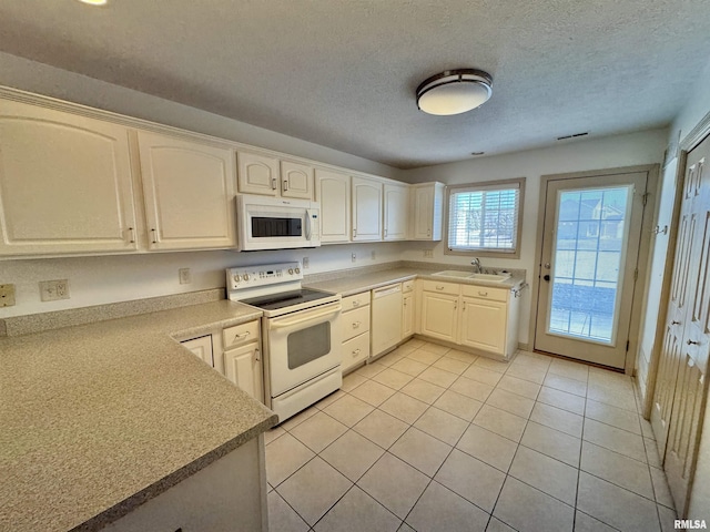 kitchen featuring sink, white appliances, white cabinets, a textured ceiling, and light tile patterned flooring