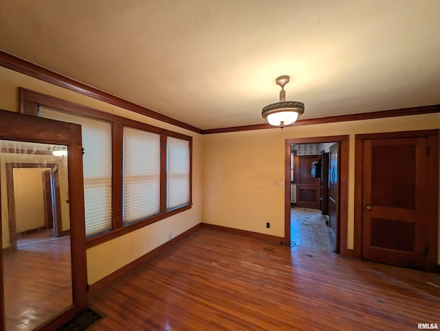 spare room with ornamental molding and dark hardwood / wood-style flooring