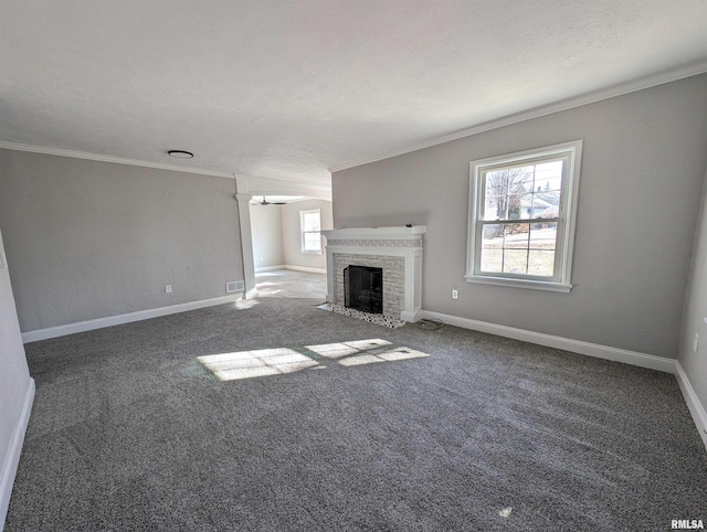 unfurnished living room featuring dark colored carpet, crown molding, a fireplace, and a textured ceiling