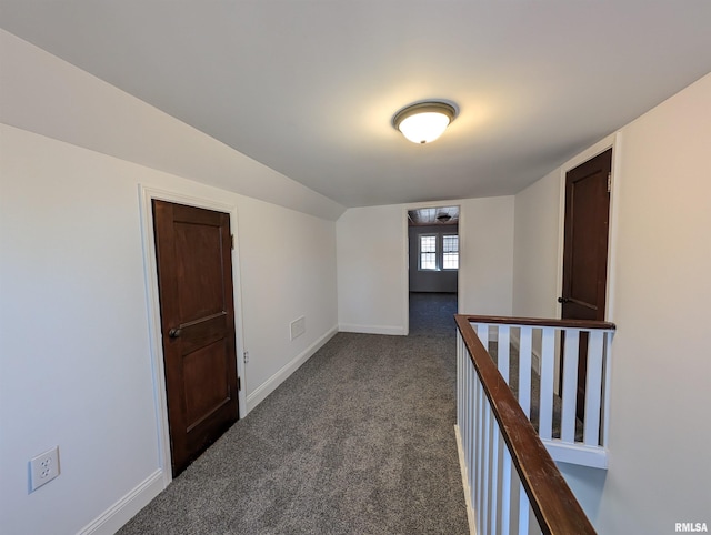 interior space with vaulted ceiling and dark carpet