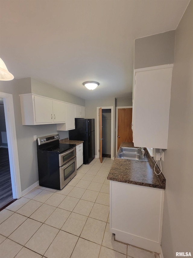 kitchen featuring sink, white cabinetry, double oven range, black refrigerator, and light tile patterned flooring