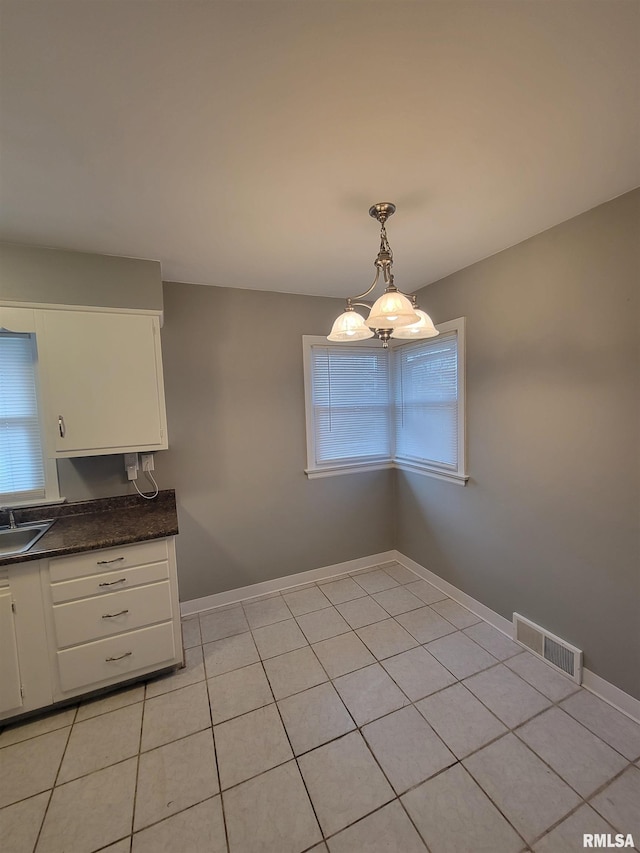 unfurnished dining area with light tile patterned flooring and sink