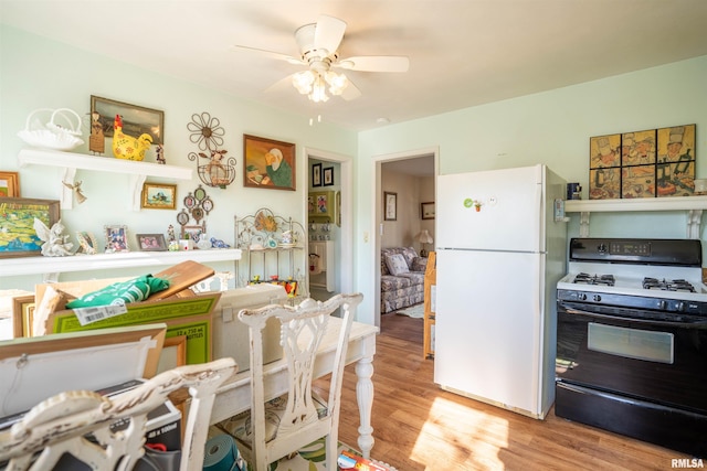 kitchen featuring range with gas cooktop, light hardwood / wood-style floors, ceiling fan, and white fridge