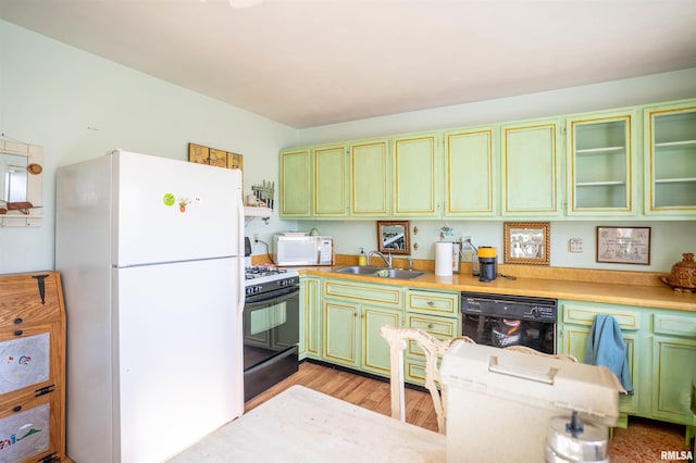 kitchen featuring sink, light hardwood / wood-style flooring, black appliances, and green cabinets