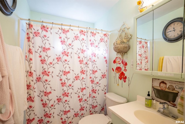 bathroom featuring vanity, curtained shower, and toilet