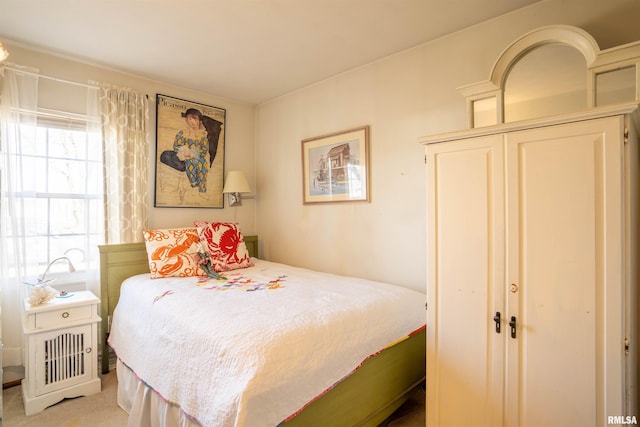 bedroom featuring light carpet and a closet