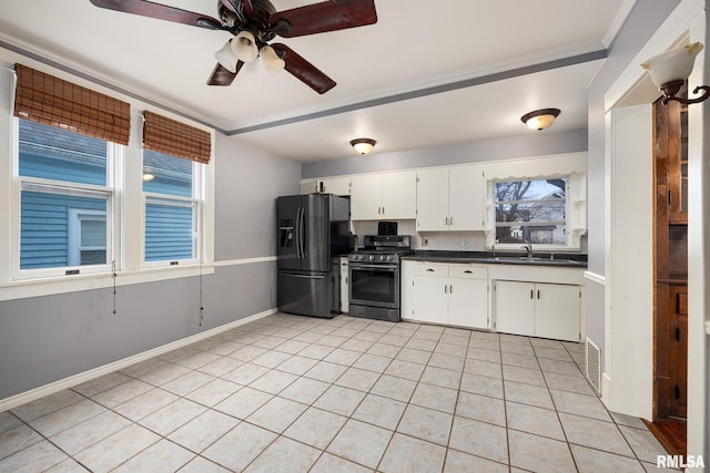 kitchen featuring light tile patterned flooring, sink, white cabinets, black fridge, and stainless steel range oven