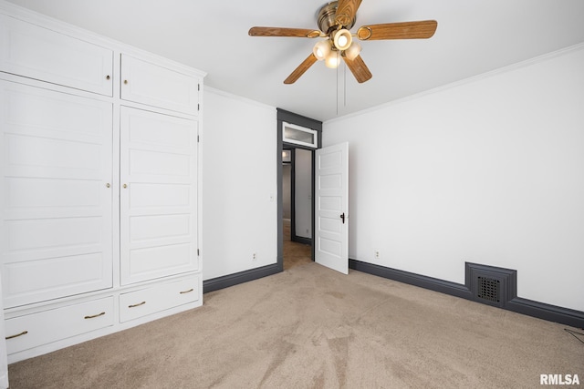 unfurnished bedroom featuring light carpet, crown molding, and ceiling fan