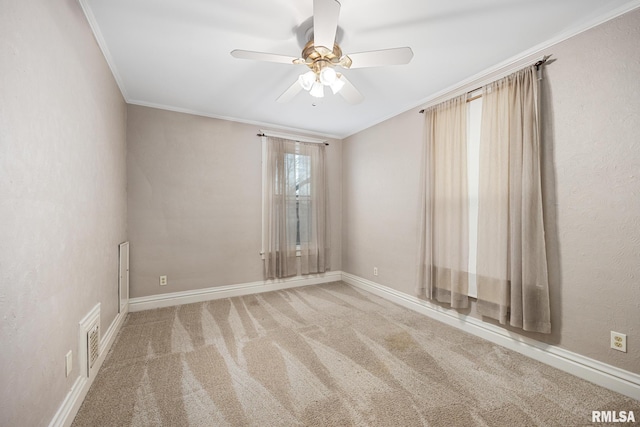 carpeted spare room featuring crown molding and ceiling fan