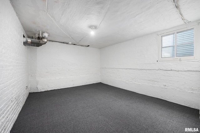 basement with carpet floors and brick wall