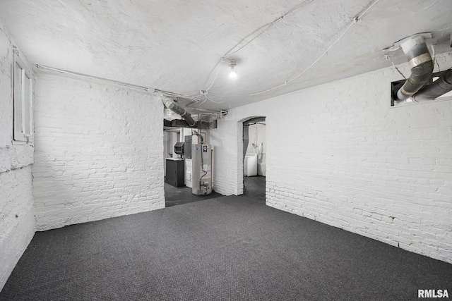 basement with dark colored carpet, washer / clothes dryer, and gas water heater