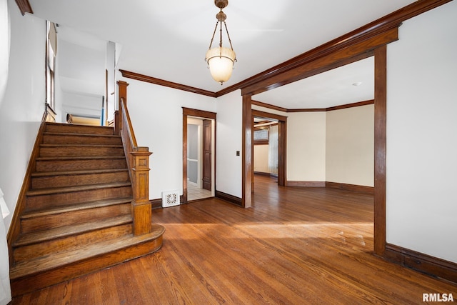 stairway featuring crown molding and hardwood / wood-style floors