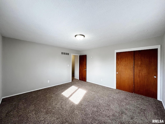 unfurnished bedroom with carpet flooring, a textured ceiling, and a closet