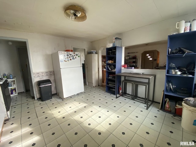 kitchen with tile walls, range, and white refrigerator