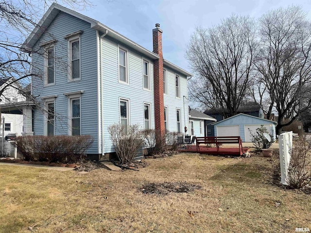 view of property exterior with a garage, an outdoor structure, and a yard