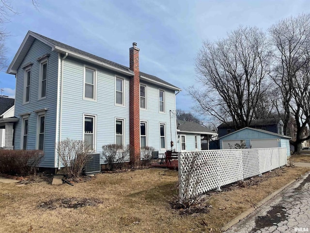 view of side of home featuring central AC unit, a garage, and an outdoor structure