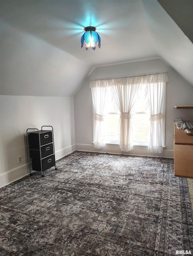 bonus room featuring dark carpet and vaulted ceiling