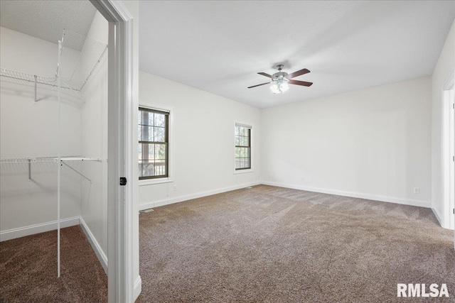 carpeted spare room with ceiling fan